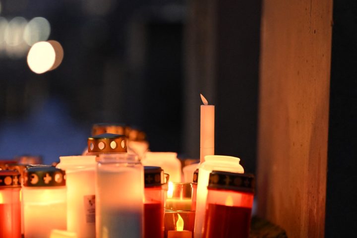 Le luci delle candele ardono tra le stele coperte di neve al Memoriale dell'Olocausto a Berlino, Germania (Afp)