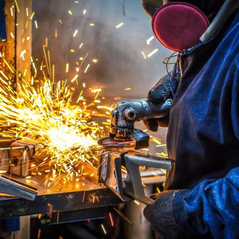 operaio che taglia l'acciaio con una smerigliatrice