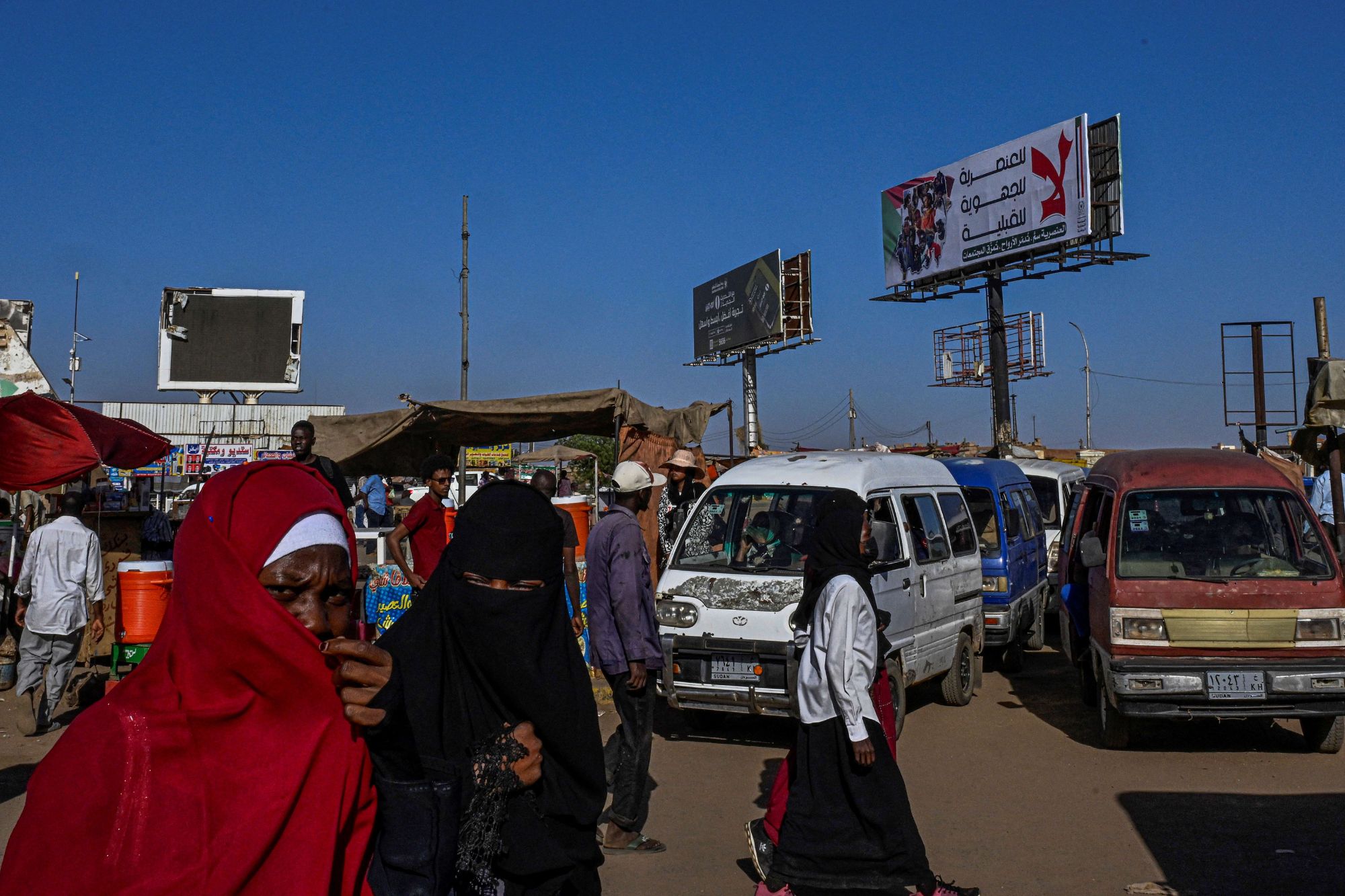 Donne sudanesi si dirigono verso la stazione dei trasporti pubblici nella capitale Khartoum (Afp)