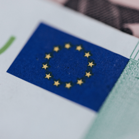 Dettaglio di una banconota euro con la bandiera dell’Unione europea in primo piano