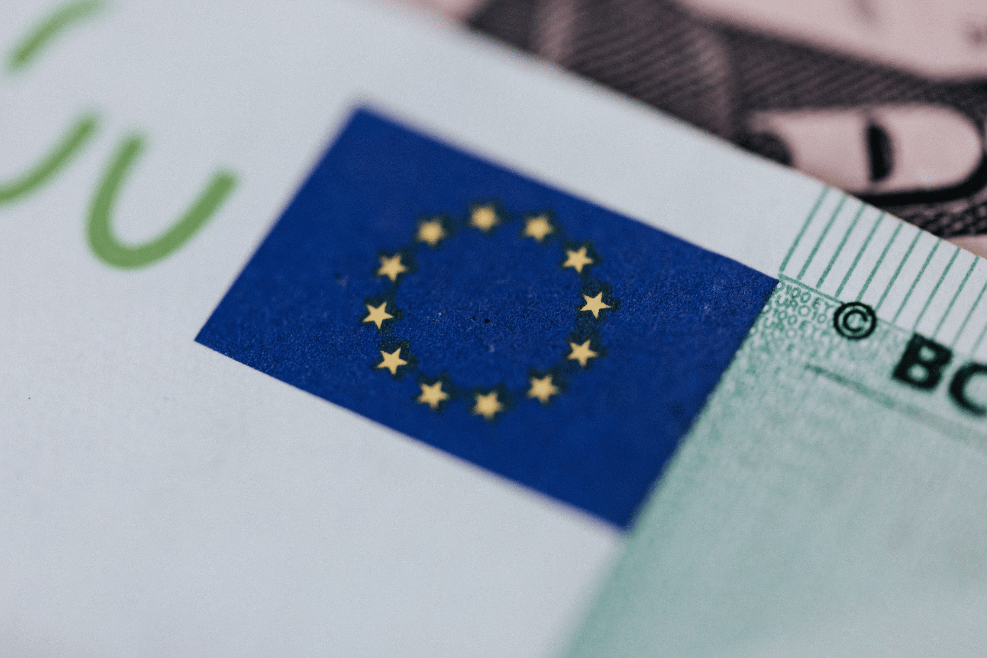 Dettaglio di una banconota euro con la bandiera dell’Unione europea in primo piano