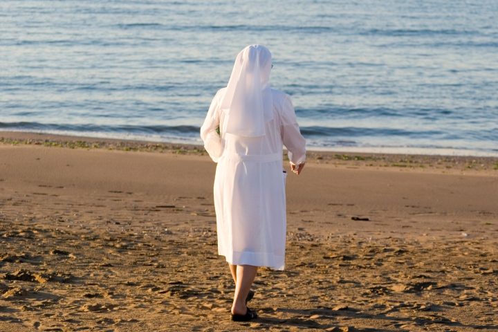 Una suora in spiaggia Canva