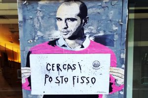 murales Checco Zalone che tiene cartello cercasi posto fisso