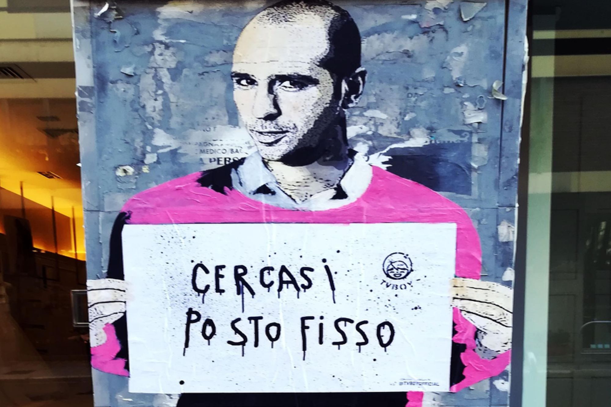 murales Checco Zalone che tiene cartello cercasi posto fisso