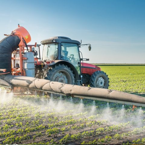 Mezzo agricolo diffonde pesticidi su un campo