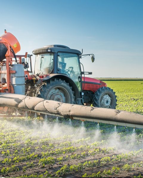 Mezzo agricolo diffonde pesticidi su un campo