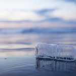 Bottiglia di plastica in spiaggia a mare - Canva