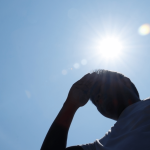 Uomo si ripara dal sole durante una giornata di caldo intenso