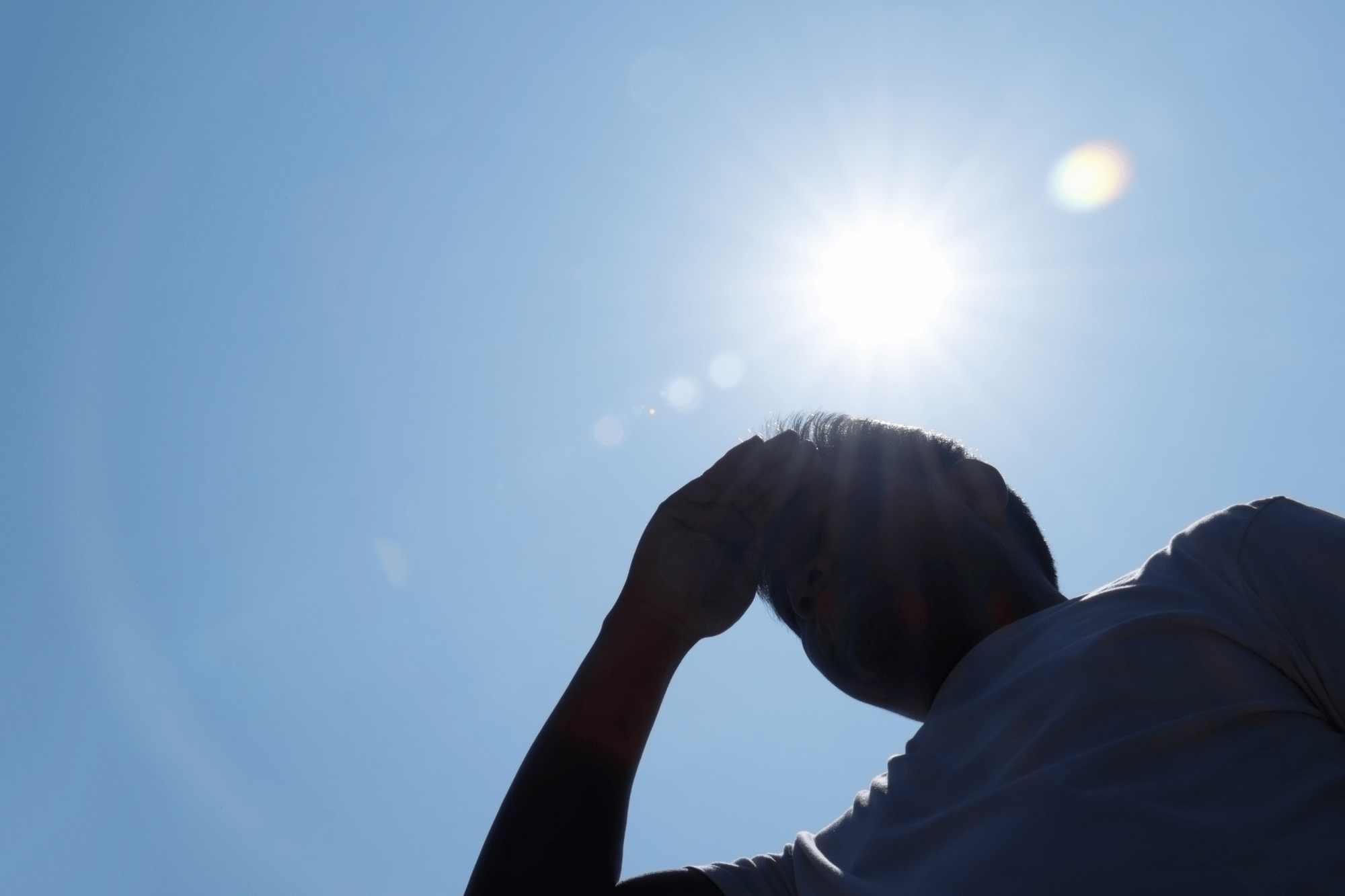 Uomo si ripara dal sole durante una giornata di caldo intenso