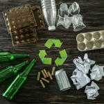 Bottiglie di vetro, lattina, carta, plastica, cartone e simbolo del riciclo