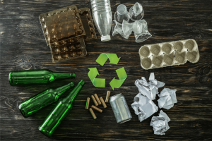 Bottiglie di vetro, lattina, carta, plastica, cartone e simbolo del riciclo