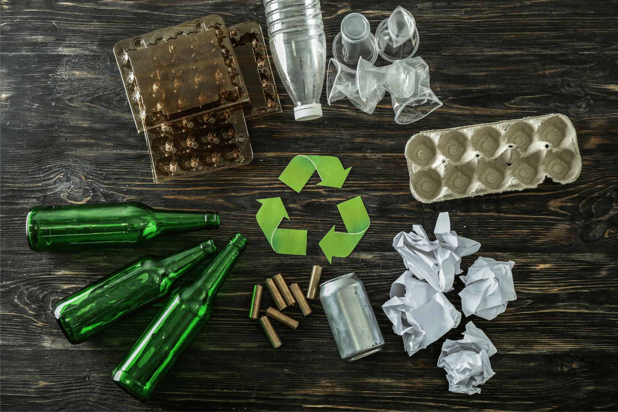 Bottiglie di vetro, lattina, carta, plastica, cartone e simbolo del riciclo