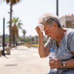 Signora su una panchina soffre il caldo