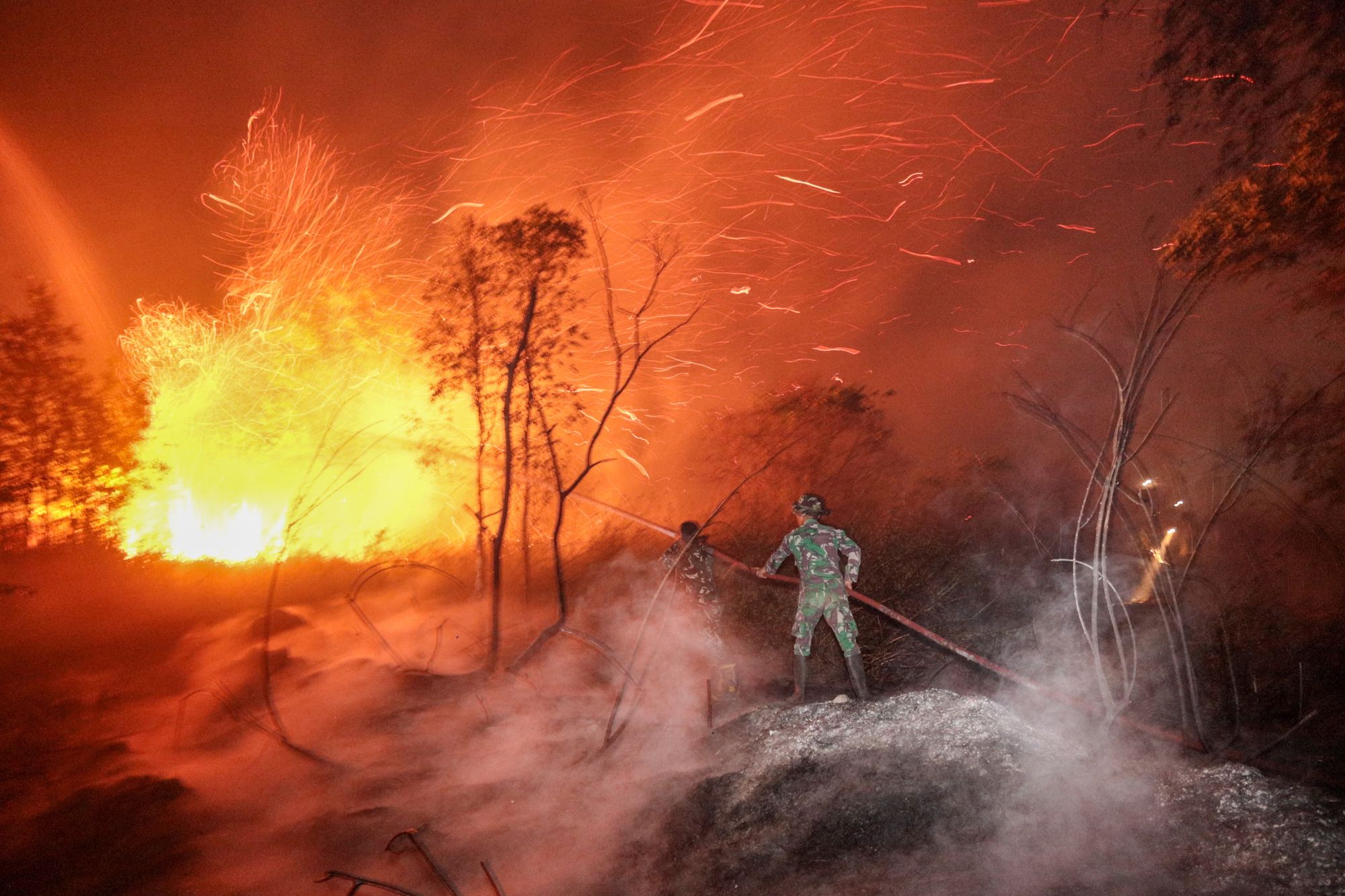 Soldati e vigili del fuoco lavorano per contenere un incendio boschivo a Banjarbaru, nella provincia del Kalimantan Meridionale